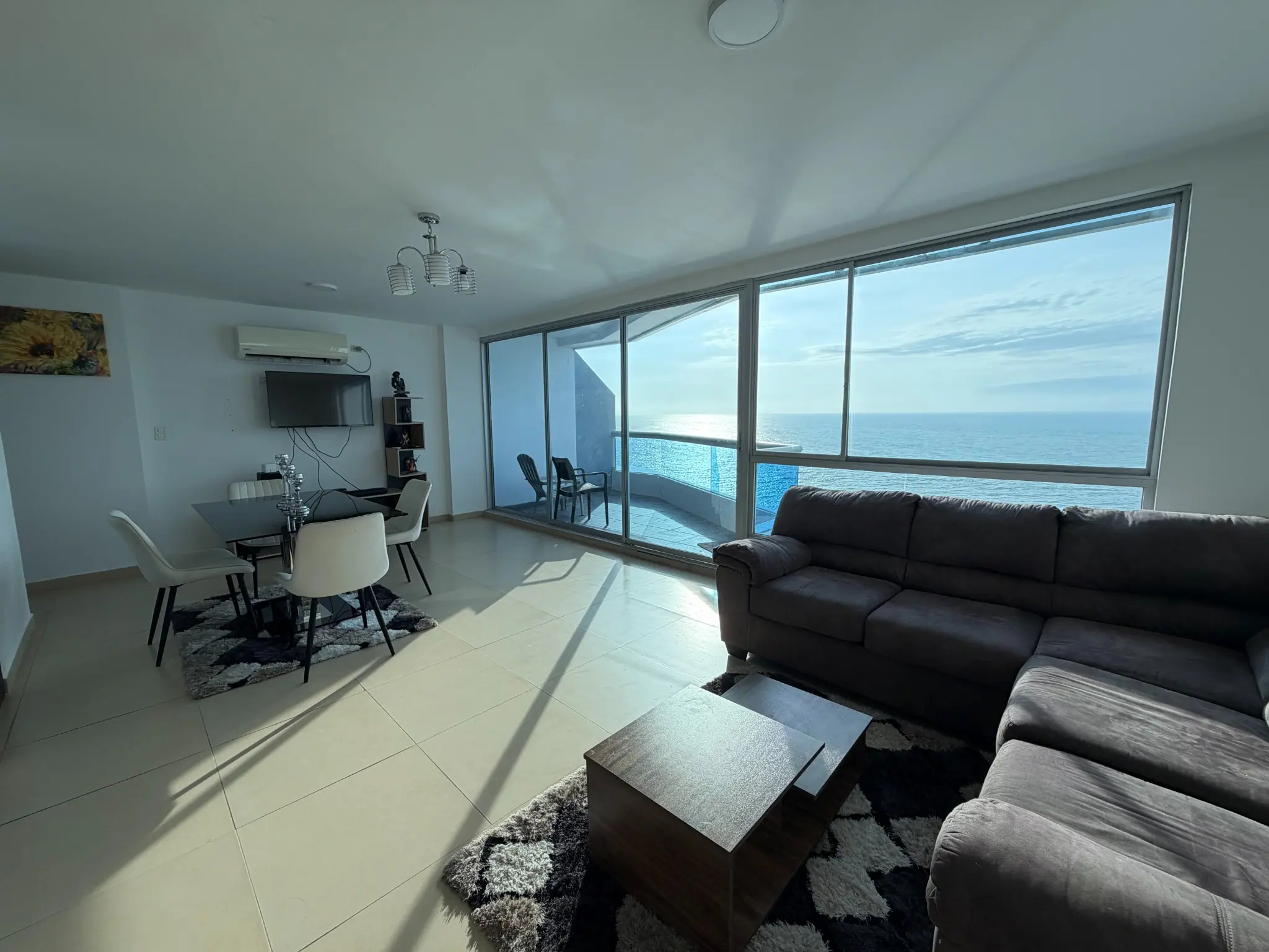 Sala y comedor del penthouse con vista panorámica al océano