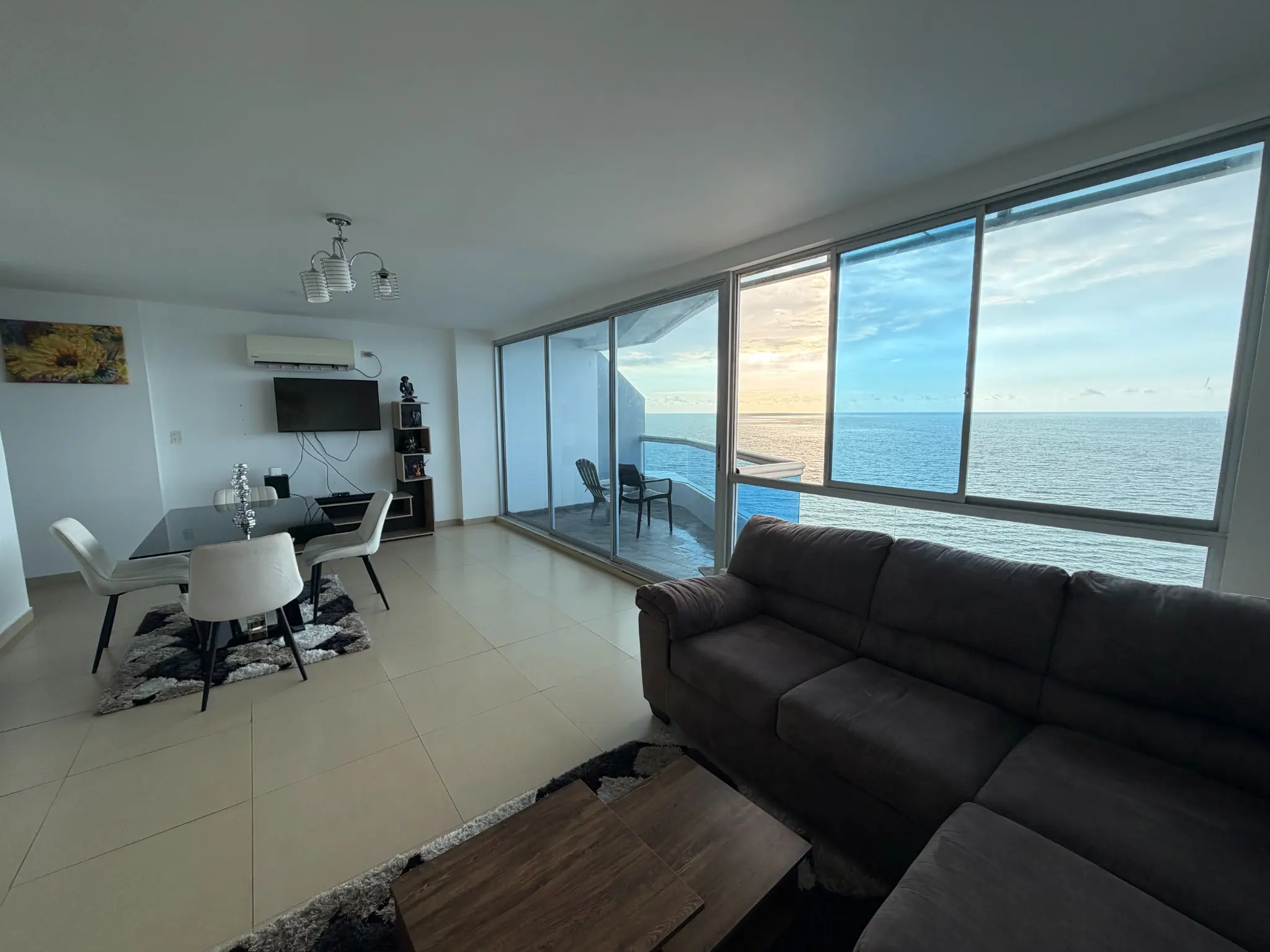 Área social del penthouse iluminada por el atardecer